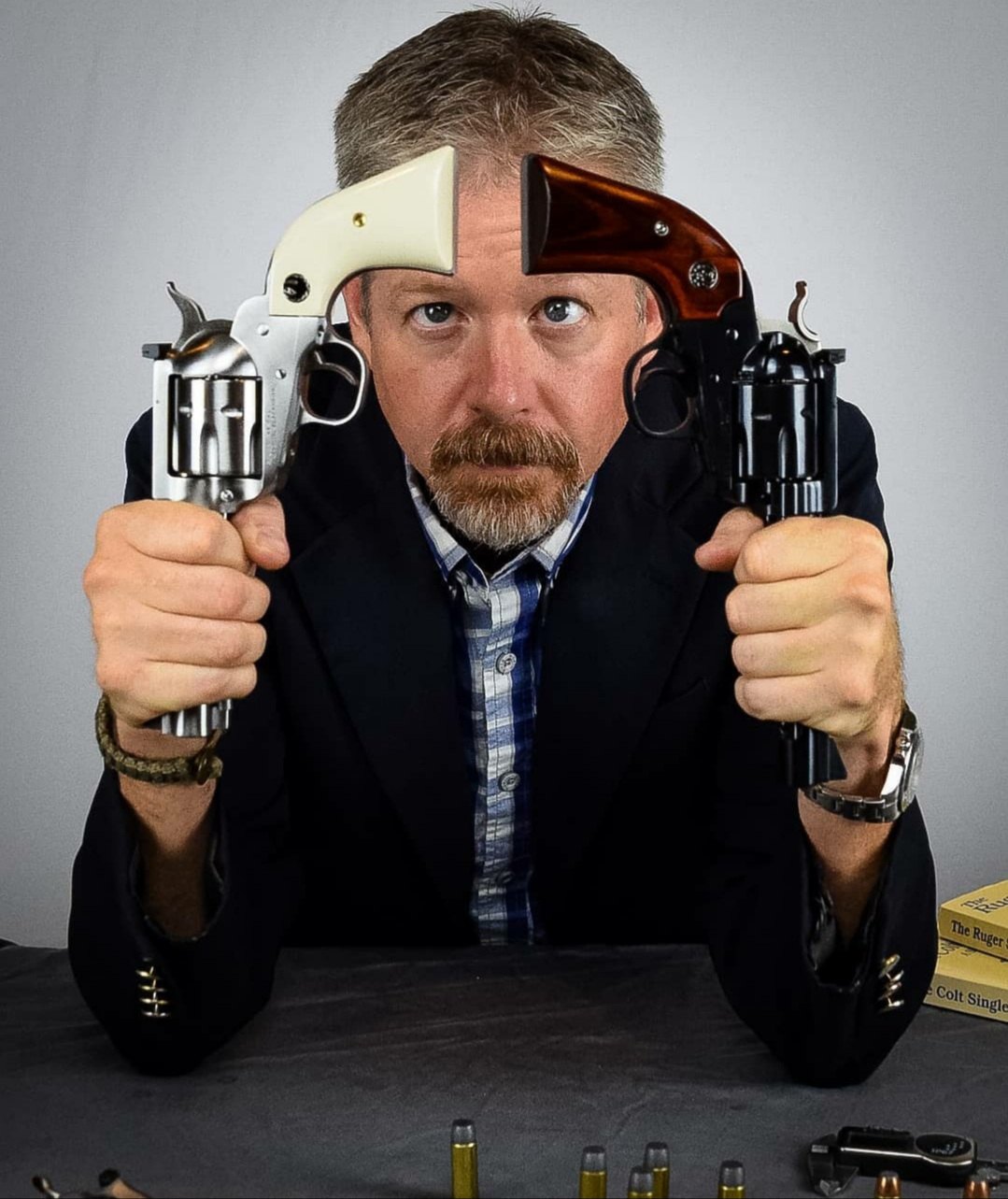 Jon Wayne Taylor holding a stainless and a blued single-action revolver